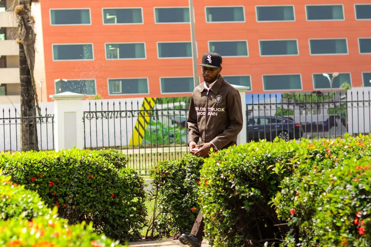 A security officer walking a garden path in Abuja